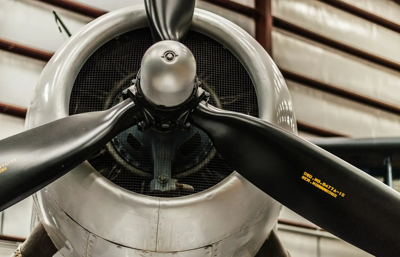 Radial engine cowling and propeller hub on an aircraft parked inside a hangar